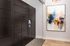 Modern package locker room with sleek black units and vibrant abstract artwork, offering a stylish and secure solution for residents.