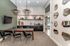 Elegant dining area with modern pendant lights, wall-mounted TV, and a stylish kitchenette with upscale decor.