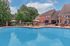 Charming residential outdoor pool area with cozy seating and lush greenery, perfect for relaxation and social gatherings.