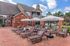 Charming terrace with cozy loungers, vibrant umbrellas, and inviting outdoor space showcasing modern brick architecture.