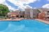 Charming apartment complex with a sparkling pool and inviting patio area, perfect for relaxation and leisure.
