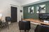 Contemporary office space with elegant black chairs, modern artwork, and a sleek computer setup.