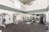 Bright, modern gym with high ceilings and large windows, featuring diverse exercise equipment for a full workout experience.