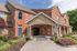 Charming brick and stone apartment building with lush landscaping and vibrant flower beds.