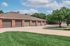 Charming community garages set against a backdrop of lush greenery and blue skies, offering spacious parking solutions.