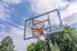 Inviting outdoor basketball hoop against a backdrop of clear blue skies and lush trees, perfect for sports enthusiasts.