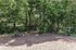 Tranquil outdoor space featuring a cozy picnic table surrounded by lush greenery and a secure fence.