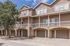 Charming townhouse with a spacious balcony, stone facade, and multiple garage entries, perfect for comfortable urban living.