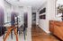 Elegant dining room with a modern glass table, stylish chairs, chic wall art, and ambient lighting; perfect for entertaining.