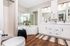 Elegant bathroom featuring a modern double vanity, sleek mirrors, and luxurious corner bathtub with decorative plants.