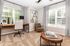 Cozy home office with chic decor, large windows, and plush carpeting, perfect for inspiring productivity and comfort.