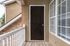 Charming apartment entrance with elegant black door and bright windows, set against a stylish stone exterior.