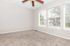 Bright and inviting room with plush carpet, large windows, and a ceiling fan, perfect for a cozy retreat.