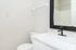 Modern bathroom featuring a sleek black faucet, large mirror, and elegant marble countertop for a stylish touch.