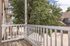 Charming balcony view featuring a serene neighborhood street and lush greenery, perfect for relaxation.