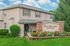 Charming Pine Meadow Townhomes featuring lush landscaping, vibrant flower beds, and elegant architecture, perfect for serene living.