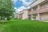 Charming apartment complex with lush green lawns, spacious patios, and a serene suburban setting.
