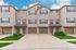 Charming townhouse exterior with two-car garages and welcoming entrances, nestled in a well-maintained neighborhood.