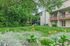 Charming apartment view with lush green lawn and vibrant garden, perfect for nature lovers seeking tranquility.