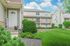 Charming apartment exterior with lush green landscaping, welcoming porch, and vibrant surroundings.