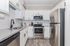 Sleek modern kitchen with stainless steel appliances, granite countertops, and chic white cabinetry.
