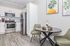Modern kitchen with sleek stainless steel appliances, elegant cabinetry, and a cozy dining area with stylish decor.