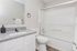 Bright, modern bathroom featuring sleek granite countertops, elegant vanity, and spacious shower with frosted glass doors.
