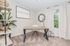 Charming home office space with modern desk, stylish decor, and large window offering natural light.