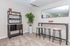 Chic basement bar area with sleek shelving, stylish bar stools, and a decorative mirror, perfect for entertaining.