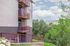Charming apartment exterior with private balconies overlooking lush green landscape and distant mountains.