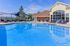Inviting pool area with elegant lounge seating and a contemporary clubhouse backdrop, perfect for relaxation and social gatherings.