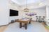 Inviting game room featuring a stylish pool table, plush seating, and modern decor under soft lighting.