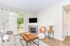 Bright and inviting living room with a cozy fireplace, modern decor, and large windows overlooking greenery.