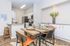 Modern kitchen and dining area with stylish decor, featuring sleek appliances, granite countertops, and a chic dining set for four.