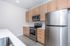 Modern kitchen with sleek stainless steel appliances, elegant wooden cabinetry, and a bright, spacious feel.