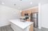 Modern kitchen with sleek stainless steel appliances, spacious island, and elegant pendant lighting.