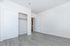 Bright, spacious bedroom with sleek laminate flooring and a large closet, ideal for comfortable modern living.