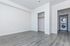 Modern apartment interior with sleek gray flooring, spacious closet, and convenient laundry area with stacked washer and dryer.