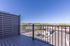 Spacious balcony with stunning mountain views, modern railing, and sleek wooden flooring.
