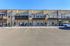 Modern apartment building with private balconies, ample parking, and sunny exterior in a vibrant neighborhood.