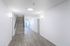 Modern apartment hallway with sleek wooden flooring, contemporary lighting, and a stylish staircase.