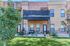 Charming brick townhouse with a cozy patio, lush green lawn, and scenic views.