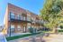 Contemporary brick apartment complex with private balconies and lush greenery, offering a serene and modern living experience.