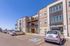 Modern apartment complex with spacious balconies, ample parking, and a sunlit facade.