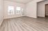 Bright and spacious room with elegant wood flooring, large windows, and inviting natural light.