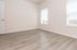 Bright, inviting room with elegant laminate flooring and ample natural light from large windows.