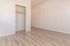 Sleek and modern bedroom with light wood flooring, built-in closet, and minimalistic design.