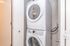 Modern laundry area featuring a sleek, stacked washer and dryer, conveniently enclosed in a compact space.