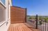 Charming balcony with modern wood paneling and scenic view, perfect for relaxation.
