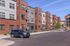 Modern apartment complex with stylish architecture and ample parking in a serene setting.